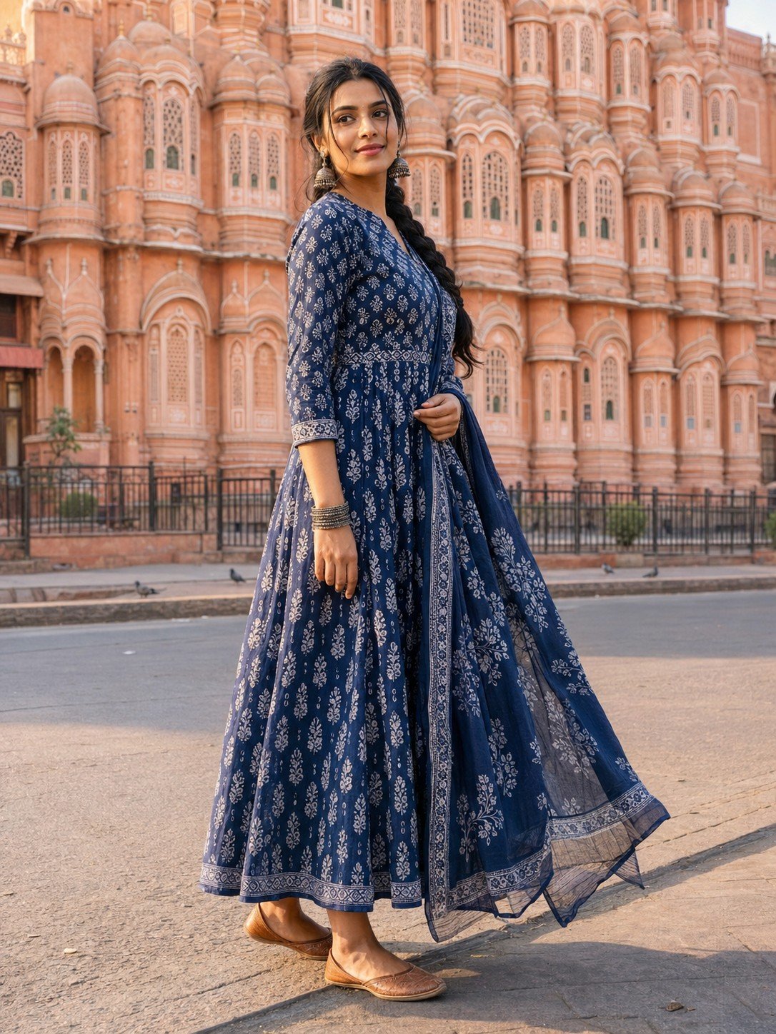 Indian woman in an indigo dress outside Hawa Mahal at sunrise